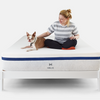 Woman and dog sitting on Helix mattress on Helix white wood bed frame