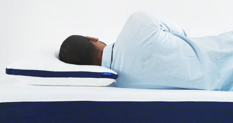 person laying down on a Helix Sleep adjustable pillow