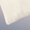 A closeup image of the Organic Pillow on a blue background