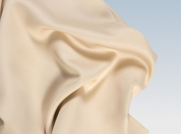 A closeup of the Tencel Sheet Set on a blue background