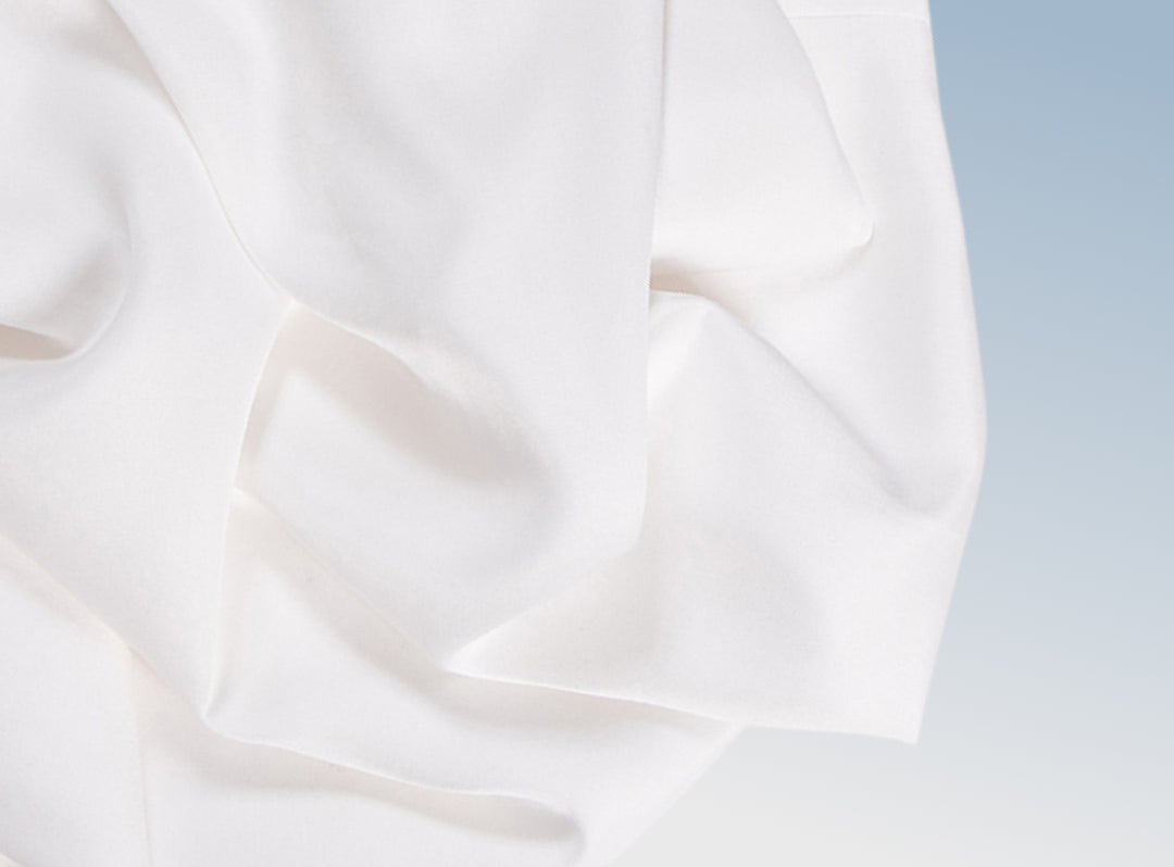A closeup of the Tencel Sheet Set on a blue background
