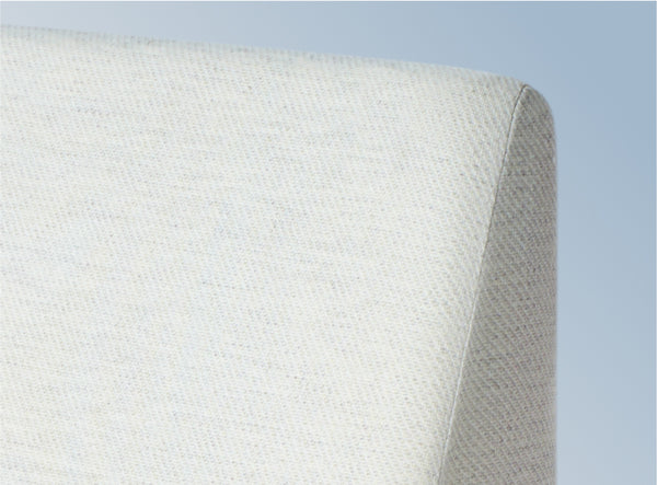 A closeup image of the Helix Wedge Pillow on a blue background