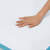 Hand pressing down on the soft Helix Sunset Mattress